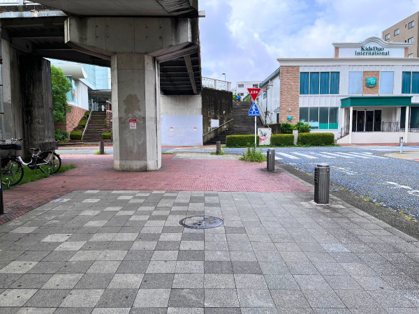 ショッピングモールの横を過ぎたあと、歩道橋の柱を回り込む歩道