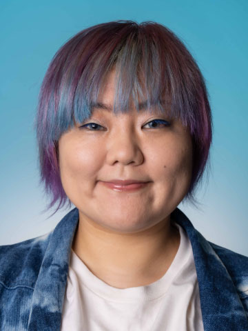 スタッフのポートレート写真。カラフルに染めた髪がトレードマークの、明るくエネルギッシュな印象の女性。以下はそのプロフィールです。